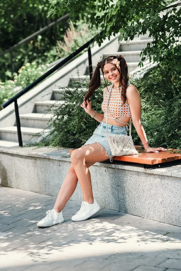 cheerful-young-woman-fashionable-crop-top-denim-shorts-relaxes-park-bench-sunny-day-smiles-enjoying-416276172 Sự kết hợp hoàn hảo giữa quần short và giày bánh mì giúp phái đẹp tự tin dạo phố trong mùa hè